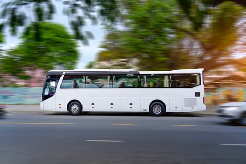 White tourist bus on the highway in travel through town by street intermediate destination